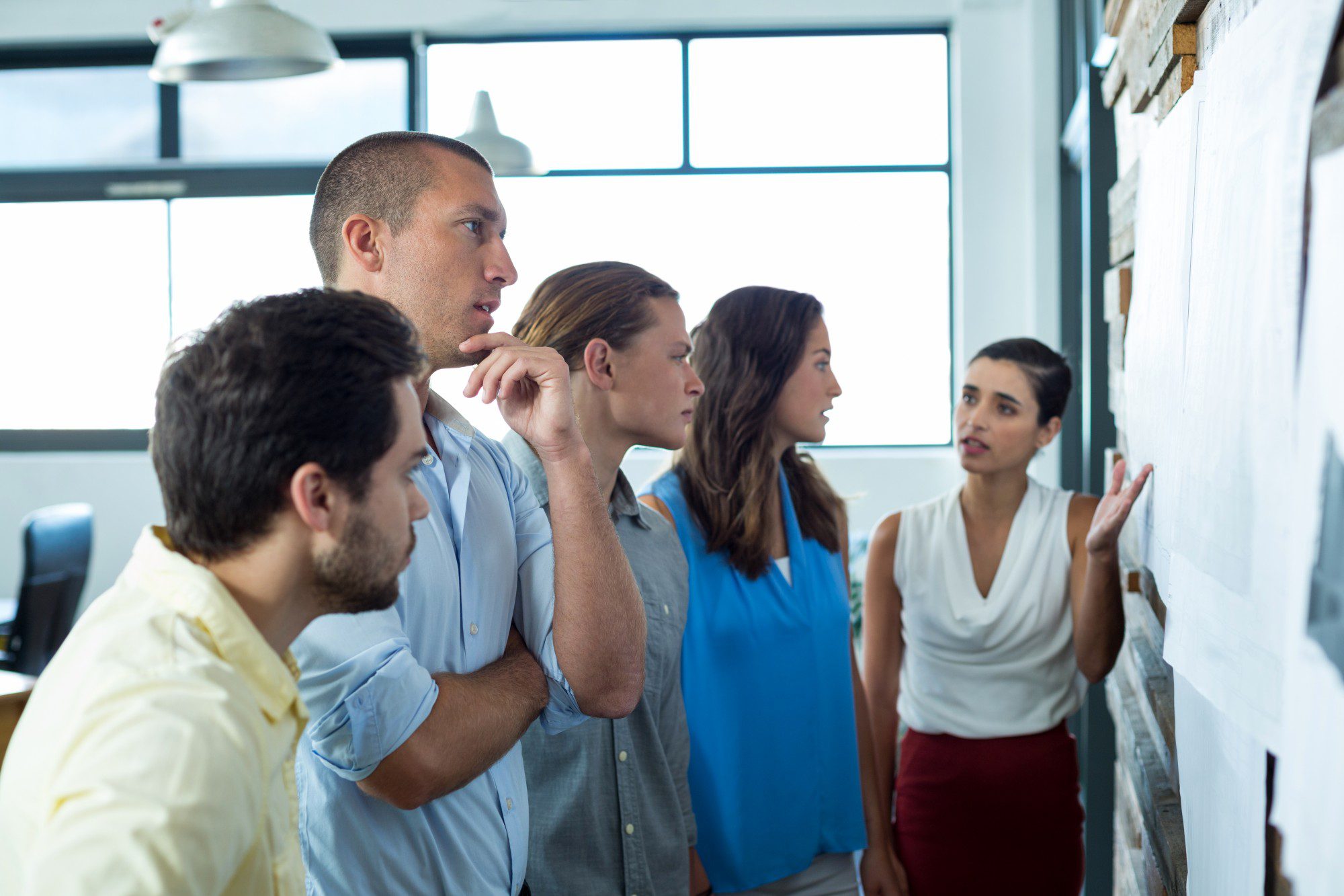 Business executives discussing over chart Business executives discussing over chart