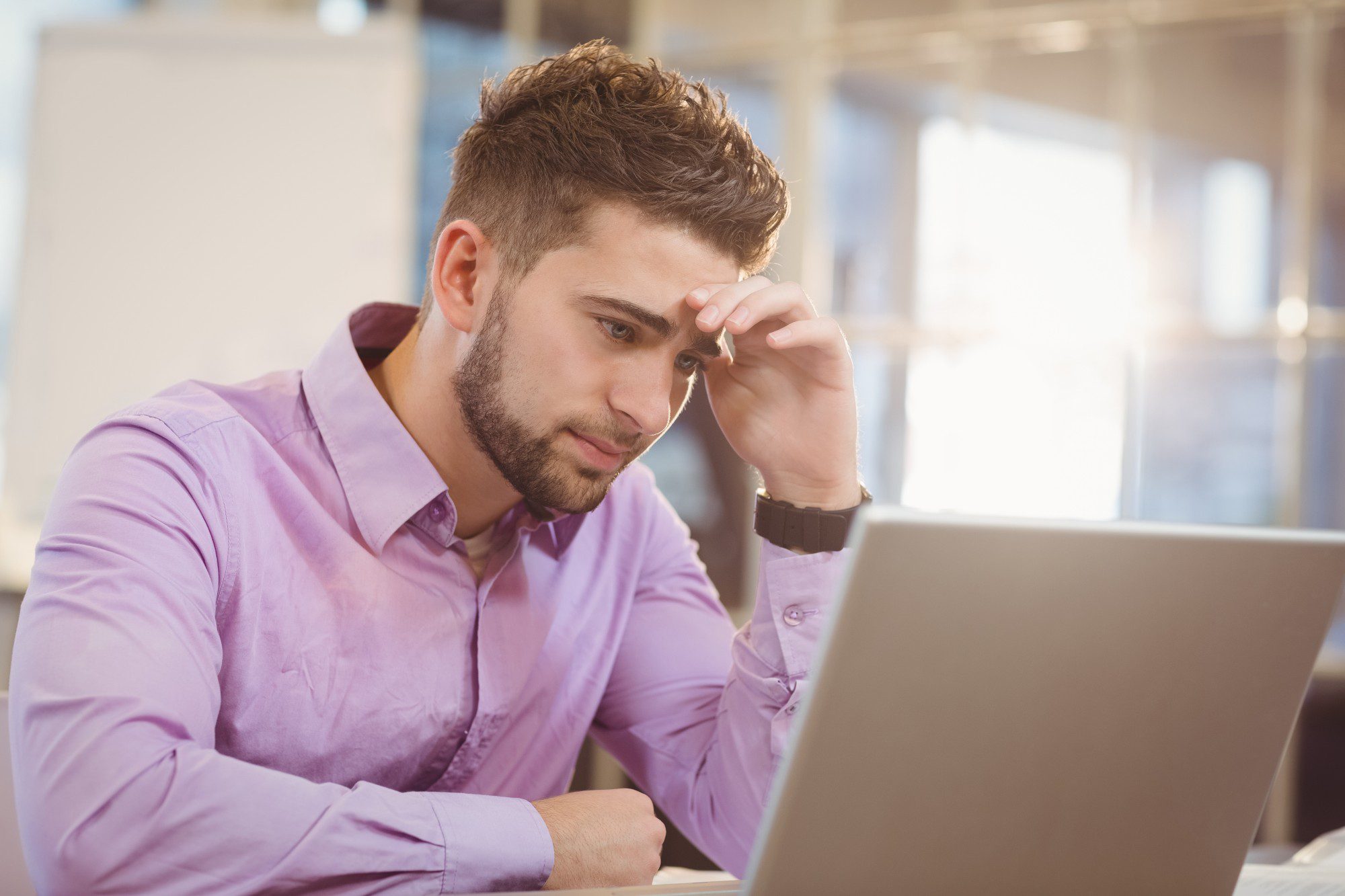 Worried businessman looking at laptop in office Worried businessman looking at laptop in office