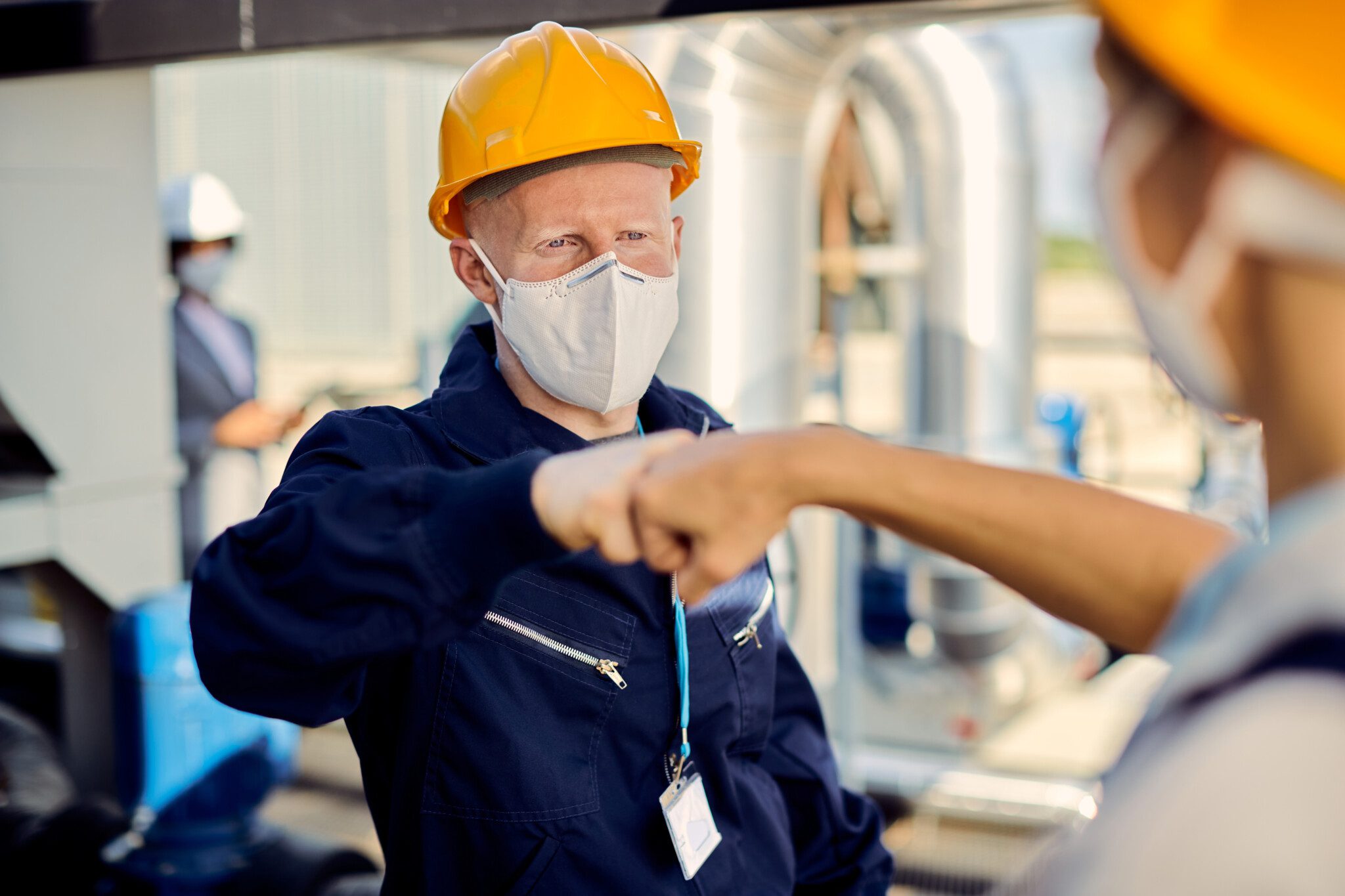 Construction workers fist bumping during coronavirus epidemic.