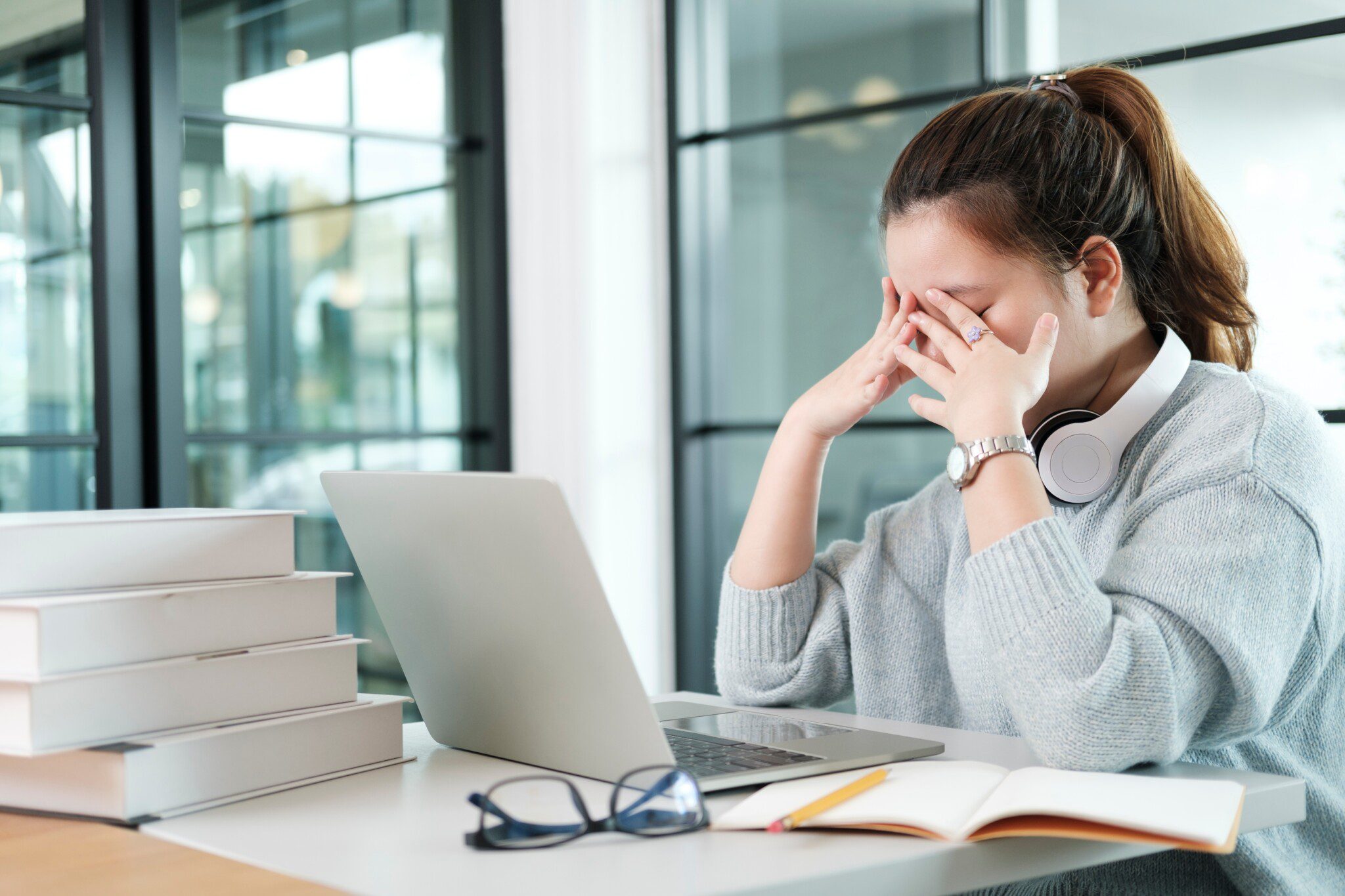 Frustrated professional woman next to stacks of paper Frustrated professional woman next to stacks of paper