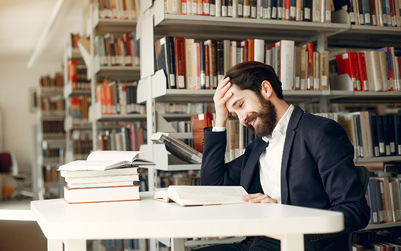 Guy in a black suit with books.