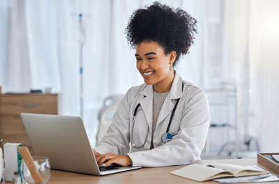 Black woman, doctor and laptop with smile for healthcare, email doctor and laptop
