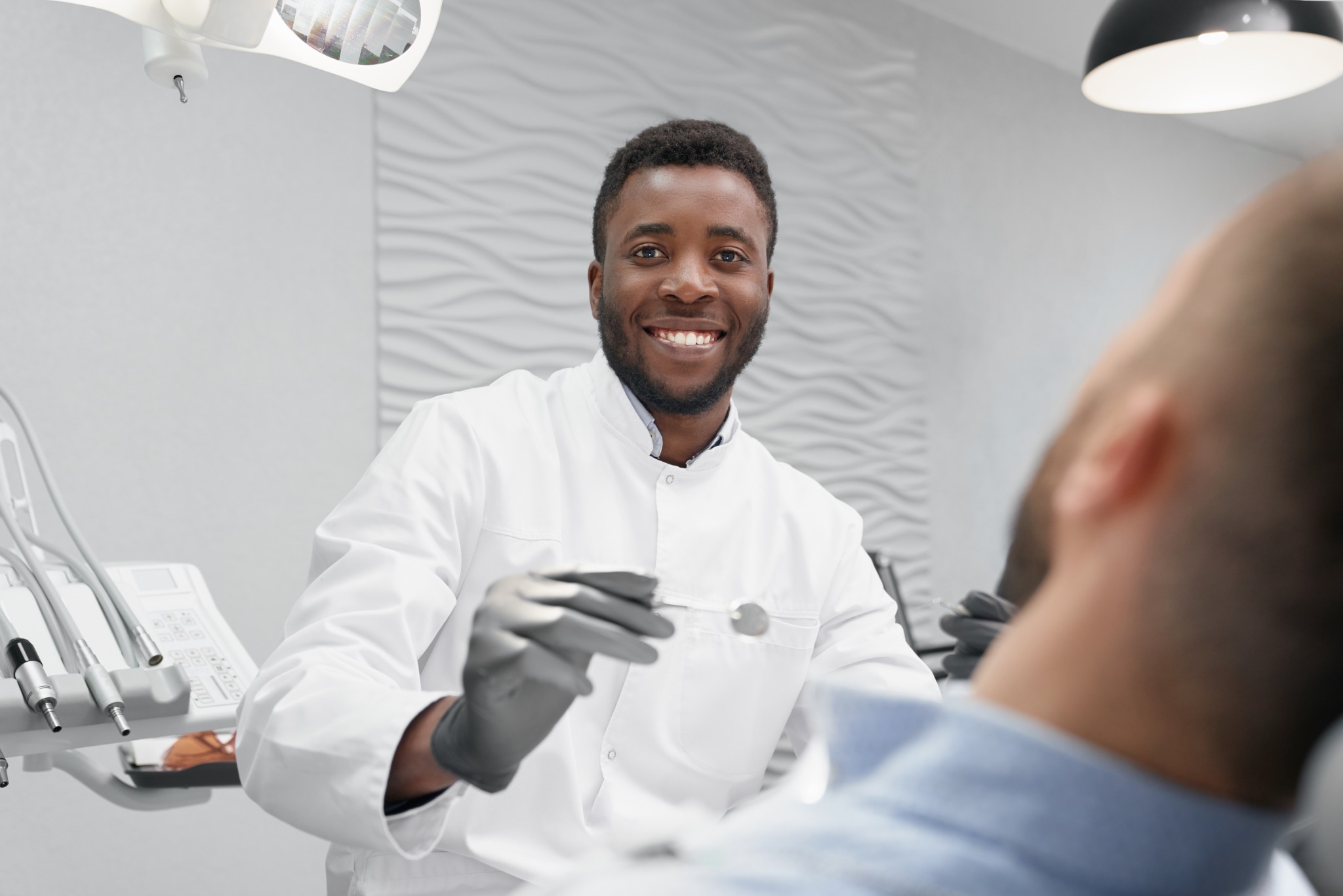 Selective focus of male dentist in process of curing teeth Selective focus of male dentist in process of curing teeth decay