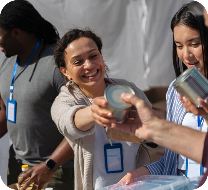 Lady smiling and handing out tins of food